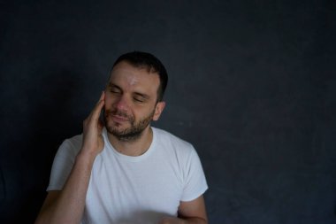  30 yaşındaki bir adam yüzüne nemlendirici krem sürüyor.                   