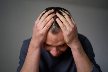         A 30-year-old man is stressed, holding his head with his hands                        clipart