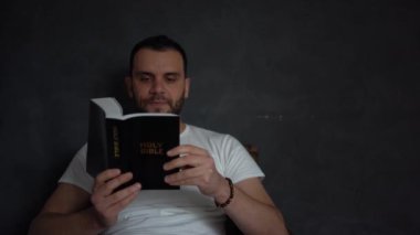 30 yaşında bir adam İncil okur ve yatakta dua eder, sabah rutini.