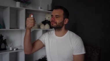 30 yaşında bir adam cildine sprey tonik sıkar.