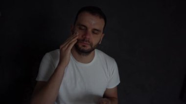 30 yaşındaki bir adam yüzüne nemlendirici krem sürüyor.