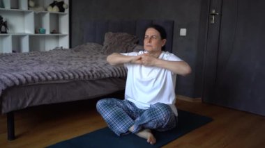 Son sınıf öğrencisi kadın evde somatik egzersizler, yoga yapıyor.