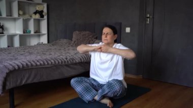 Son sınıf öğrencisi kadın evde somatik egzersizler, yoga yapıyor.