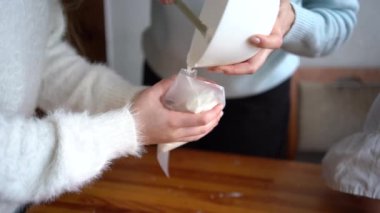 Annem ve huysuz bir çocuk mutfakta zencefilli kurabiye evi için krema pişiriyorlar.