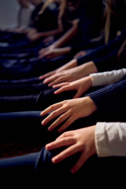 group of pre-teens perform a teacher's task during an acting class , play on the legs of other participants like a piano                        clipart