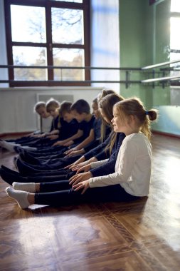 group of pre-teens perform a teacher's task during an acting class , play on the legs of other participants like a piano                        clipart