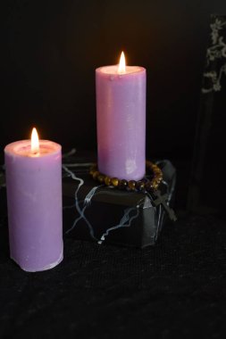 Cenaze, fotoğraf çerçevesi, mumlar, küller için mermer vazo, siyah haçlı ruhani bilezik.                   