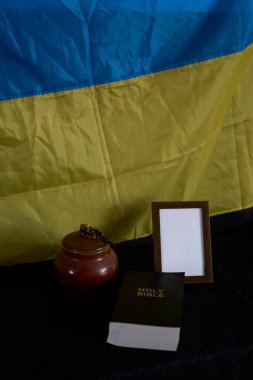        Ukraynalıların cenazesi, fotoğraf çerçevesi, mumlar, küller için mermer vazo, kutsal İncil ve siyah haçlı ruhani bilezik                                                       