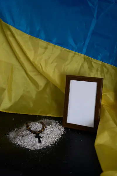        Ukraynalıların cenazesi, fotoğraf çerçevesi, küller, kutsal İncil ve siyah haçlı ruhani bilezik.                                                       