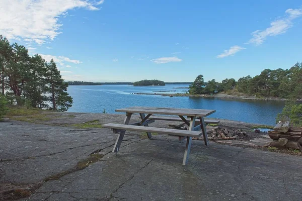 Yazın Kalliosaari adasında, Helsinki, Finlandiya 'da halka açık ateş yeri ve ahşap bank ve masa.