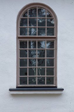 Kahverengi çerçeveli, kemerli, eski beyaz, boyalı taş bir duvar..