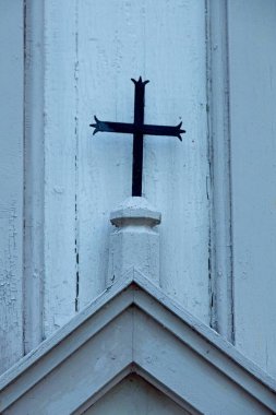 Ahşap binanın tepesinde metal bir haç var..