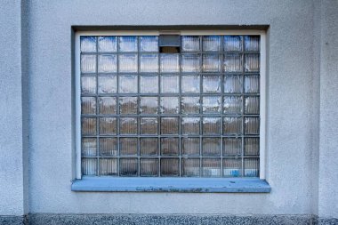 Beyaz taş duvarda cam tuğla pencere.