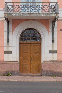 Eski bir taş binanın üzerinde pencere kemeri olan ahşap bir kapı..