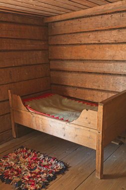 Seurasaari Açık Hava Müzesi, Helsinki, Finlandiya 'daki eski kırsal evde yatağı ve halısı olan eski bir oda..