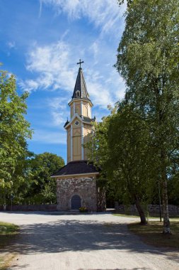 Yazın Pertteli kilisesinin ahşap çan kulesi, gökyüzünde bulutlar, Pertteli, Finlandiya.