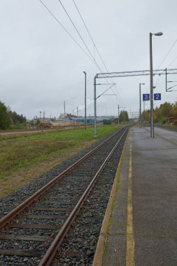 Bulutlu sonbahar havasında tren platformu, Jarvela, Finlandiya.