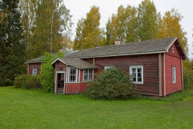 Bulutlu sonbahar havasında geleneksel kırmızı ahşap bina..