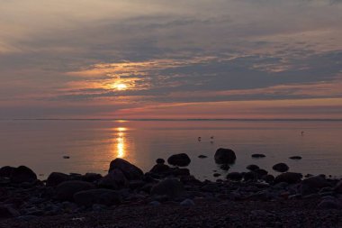 Finlandiya 'nın Kemionsaari adasında ilkbaharda deniz kıyısında renkli bir günbatımı.