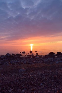 Finlandiya 'nın Kemionsaari adasında ilkbaharda deniz kıyısında renkli bir günbatımı.