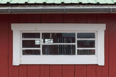 Ahşap bir binanın eski beyaz çerçeveli penceresi.