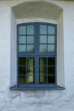 Taş bir binanın ahşap çerçeveli penceresi.