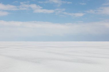 Buz, kar ve bulutlarla kaplı deniz manzaralı güneşli bahar havasında, Hailuoto, Finlandiya.