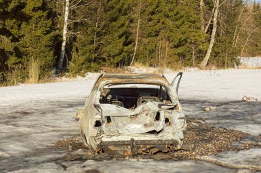 Yol kenarında yangın hasarı olan yanmış bir araba..