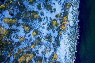 Aerial view of rocky seashore with ice in winter with snow on the ground, Porkkala, Kirkkonummi, Finland. clipart