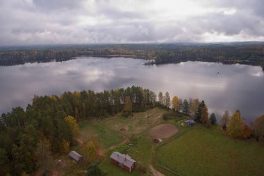 Aerial landscape view of lake Liesjarvi with reflection of cloudy sky on water surface in autumn, Tammela, Finland. clipart