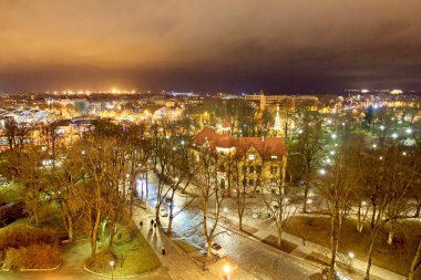 Bulutlu kış havasında Tallinn 'in binalarının ve çatılarının gece manzarası, Estonya.