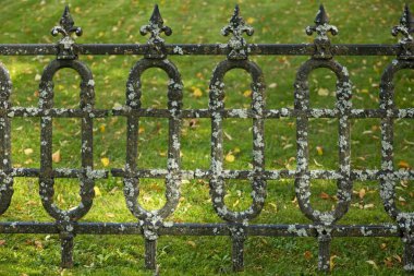 Eski, yıpranmış demir çitin yakınına..