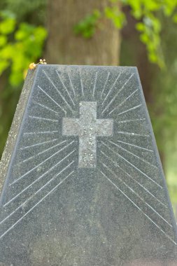 Mezarlıktaki mezar taşına eski bir haç oyması..