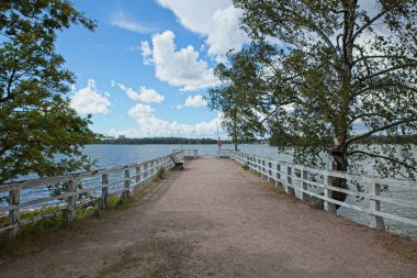 Yazın Helsinki, Finlandiya 'da Seurasaari Açık Hava Müzesi' nde beyaz tırabzanlı eski ahşap iskele..