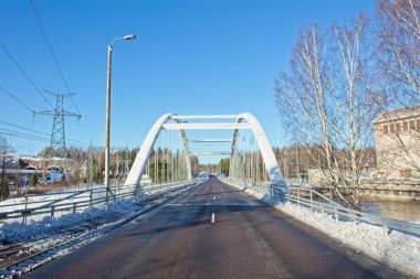 Ahvenkoski, Pyhtaa, Finlandiya 'da kışın karlı ve nehirsiz akan modern köprü.