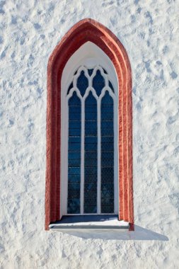Beyaz boyanmış bir binanın beyaz çerçeveli eski ahşap penceresi..