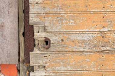 Rusty keyhole on a old yellow painted wooden door. clipart