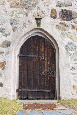 Metal kilidi ve kapı kolu olan eski ahşap kapı ve taş bir bina menteşesi..