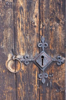 Yıpranmış ahşap kapının üzerinde metal kapı kolu olan eski metal kilidin anahtar deliği..