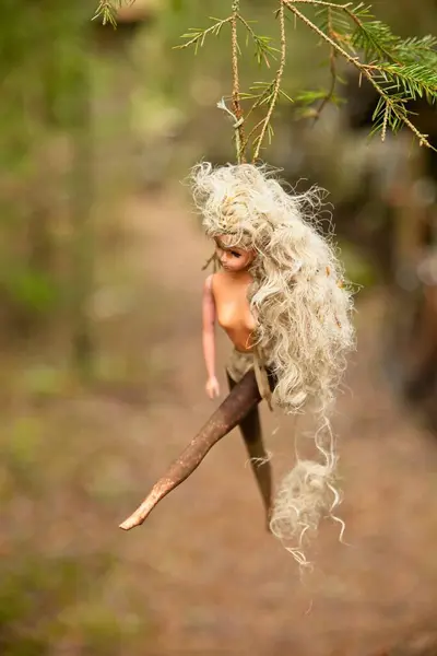 stock image Old blond naked barbie doll hanged outside.