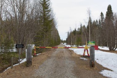 Raate, Suomussalmi, Finland - 5.10.2022: Gate closed at Finnish  Russia border zone in cloudy spring weather.