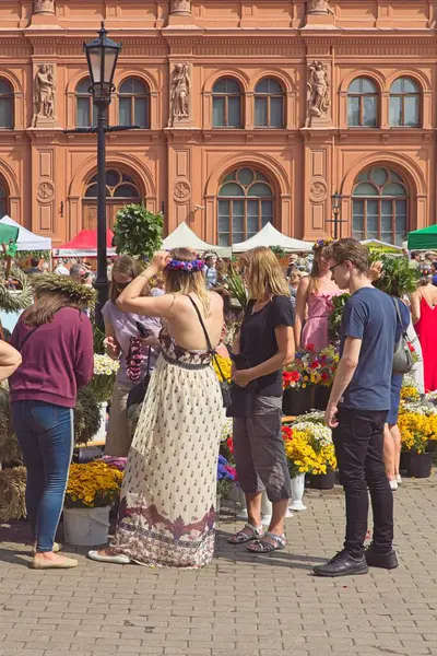 Riga, Latvia - June 21, 2019: People at market on Doma Laukums square in Old Town of Riga in mid summer.