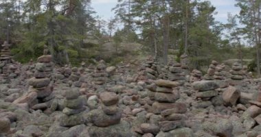 Yazın Geta, Ahvenanmaa, Finlandiya 'da Grottstigen mağara yolu boyunca kaya oluşumları ve sayısız taş yığınlarıyla dolu bir orman..