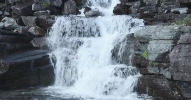 Şelale manzaralı kayalık yaz mevsiminde berrak suyla düştü, Skibotndalen, Norveç.