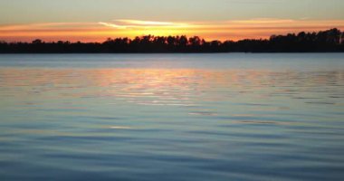 Sonbaharda deniz yüzeyine yansıyan gökyüzü renkleriyle gün batımı, Kallahti, Helsinki, Finlandiya.