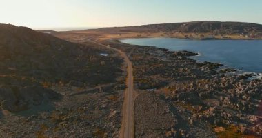 8100 numaralı sahil yolu ve güneşli yaz havasında Hamningberg kasabası, Varanger Yarımadası, Norveç.