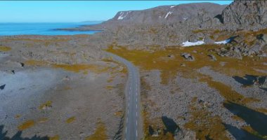 Sahil yolu 8100 'den Hamningberg' e kadar olan güneşli yaz havasında kayalık arazi, Varanger Yarımadası, Norveç.