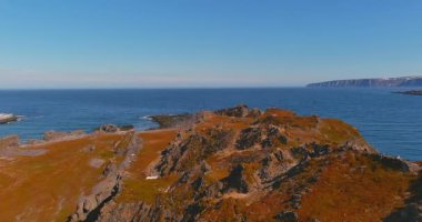 Kongsfjord 'da Barents Denizi kıyısında güneşli yaz mevsiminde 890 nolu yol boyunca uzanan bir şapkanın havadan görünüşü, Varanger Yarımadası, Norveç.