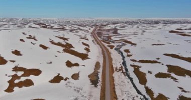Güneşli yaz mevsiminde 890 (Austertanaveien) yolu boyunca havadan görüş, yerde kar parçalarıyla, Varanger Yarımadası, Norveç.