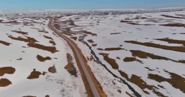 Güneşli yaz mevsiminde 890 (Austertanaveien) yolu boyunca havadan görüş, yerde kar parçalarıyla, Varanger Yarımadası, Norveç.